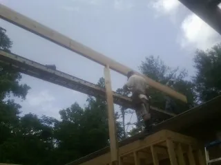 Carpenter setting a ridge beam over a new addition frame — Ice Dam Removal by Roofing Brothers in West Warwick