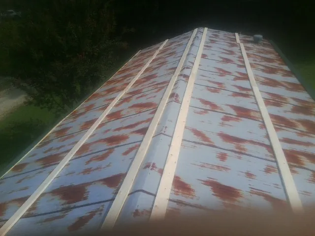 Rusted metal roof panels with new wood purlins before replacement — Storm Damage Roof Repair in West Warwick by Roofing Brothers