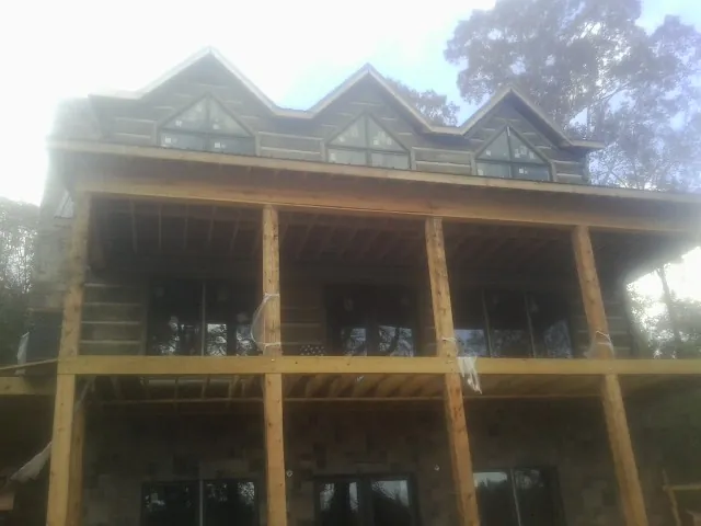 Dormers and porch framing on a large log home under construction — Roof Coating work by our crew in West Warwick