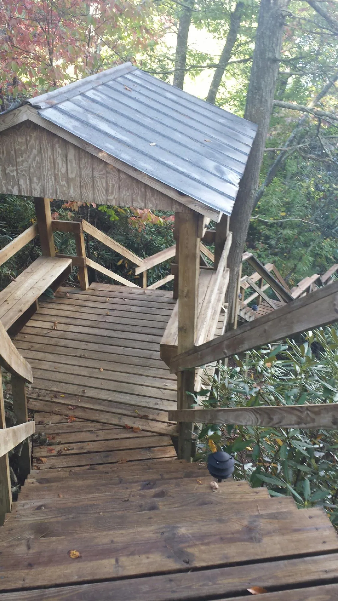 Metal roofed shelter over wooden steps on a wooded walkway — Skylight Repair & Installation work by our crew in West Warwick