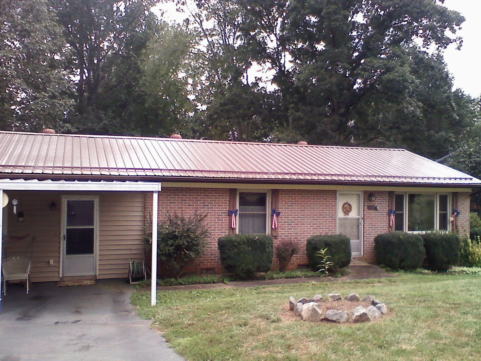 Bronze metal roof and carport on a brick ranch home — Roof Repair work by our crew in West Warwick